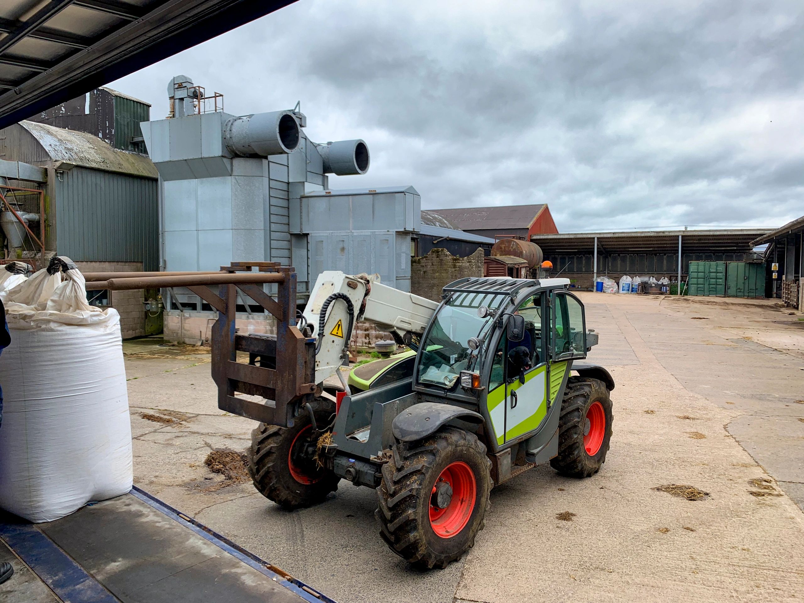 Farm equipment near agricultural buildings
